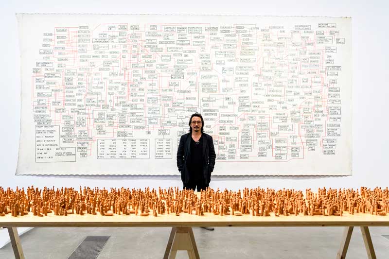Sawangwangse Yawnghwe with his exhibited works at the 9th Asia Pacific Triennial of Contemporary Art (APT9), QAGOMA Brisbane. Image courtesy the artist and Queensland Art Gallery | Gallery of Modern Art. Photo: Chloe Callistemon