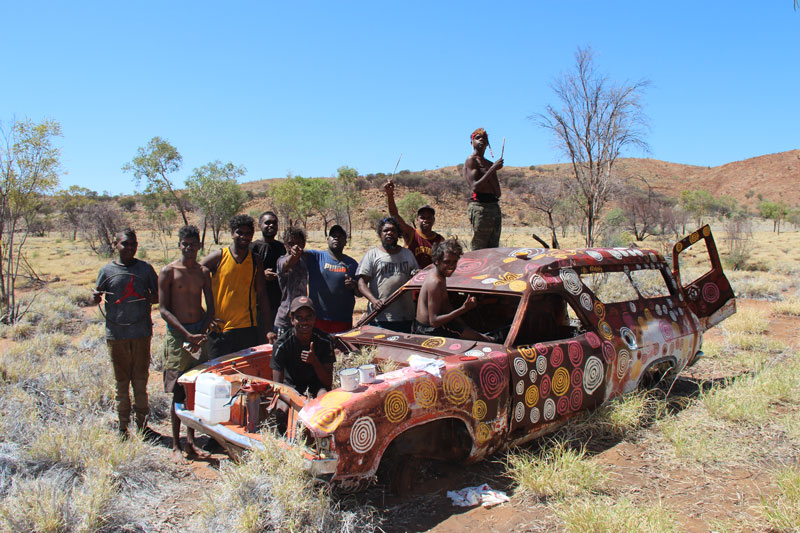 Young men learning to paint rockhole motifs at the men’s painting camp in October 2018. Courtesy Papunya Tjupi Arts, Papunya