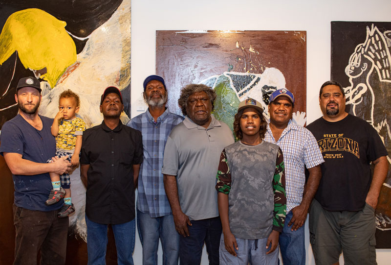 Men from the Tennant Creek Brio in front of the Nyinnkka Nyunyu showing at Desert Mob. Photo by Oliver Eclipse. From left: Rupert Betheras and son, Clifford Thompson, Fabian Brown, Mathew Ladd, Jimmy Frank and Joseph WilliamsCourtesy Araluen Arts Centre, Alice Springs