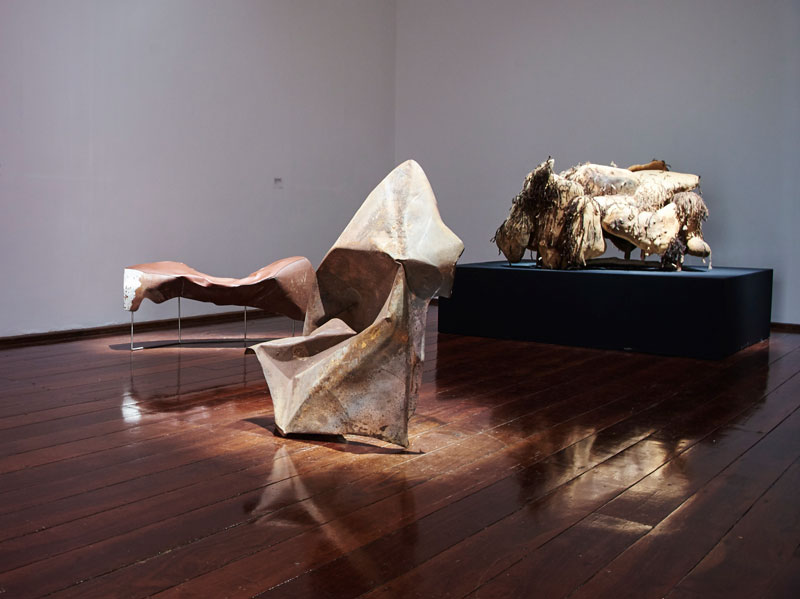 From left: Trent Jansen, Johnny Nargoodah and Duane Shaw, Collision Bench, 2017, found car bonnet, stainless steel and New Zealand cow leather; Trent Jansen, Johnny Nargoodah and Duane Shaw, Collision Vessel, 2017, found car bonnet; Elsie Dickens, Trent Jansen, Yangkarni Penny K-Lyons, Myarn Lawford, Rita Minga, Eva Nargoodah, Illium Nargoodah, Johnny Nargoodah, Duane Shaw and Gene Tighe, Jangarra Armchair, 2017, Jartalu wood, gum branches, human hair and fasteners. Photo: Rebecca Mansell. Courtesy and © the artists, Mangkaja Arts Resource Centre and Fremantle Arts Centre