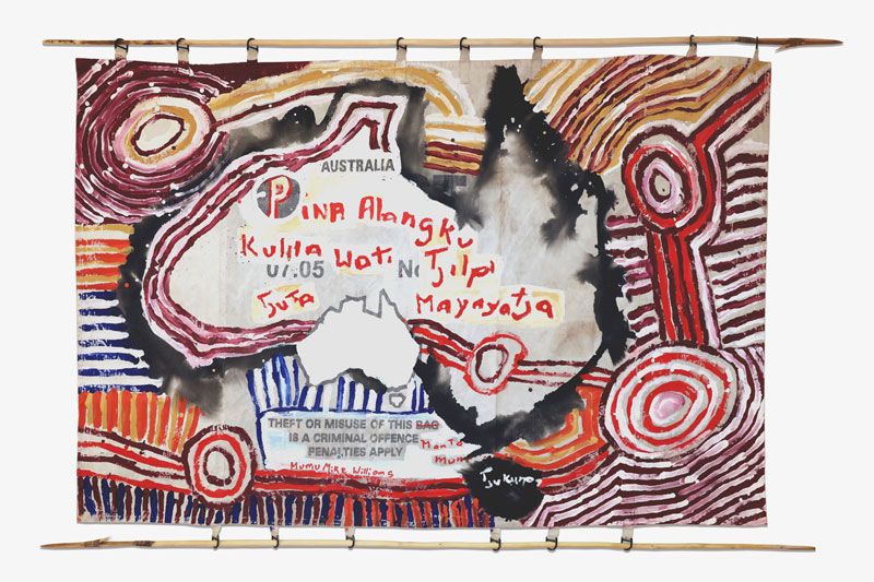 Kunmanara Williams and Sammy Dodd (spears), Pina Alangku, 2018. The painting surface is canvas from mailbags and part of the work is an intervention in their proprietorial text, so that it reads: Theft or misuse of this [bag, crossed out, replaced by manta] land and its cultural heritage is a criminal offence. The Pitjantjatjara text in English: Open your ears and listen.The senior old men are the ultimate bosses.