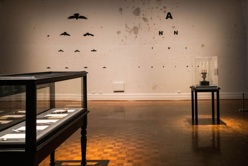 (From back) Julie Gough, Murder of Crows, 2011, plywood, paint, nails; Julie Gough with David Barclay (manufacturer), Joseph Forrester (silversmith), Bothwell Cup, 1835, engraved sterling silver, Impasse: Stolen Ground, 2019, mixed media, including clay from Bothwell, created in collaboration with Ben Richardson and IPEC Investment Casting, Melbourne. Installation view, Julie Gough: Tense Past, Tasmanian Museum and Art Gallery. Photo: Alastair Bett